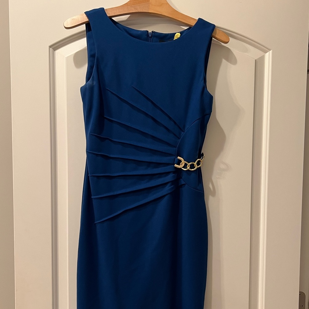 Sleeveless Royal blue sheath dress with gold chain.